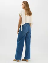 Jegging de denim azul oscuro con silueta estilo palazzo, tiro alto y pierna amplia, con pretina ancha elástica y sin bolsillos frontales.