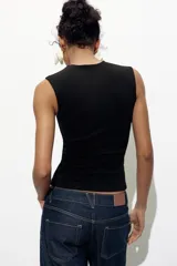 Top blanco de manga sisa con cuello redondo y corte ajustado al cuerpo.