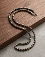 Collar masculino confeccionado con cuentas cilíndricas de acero y piedras naturales en tonos marrones y plateados.