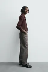 Camisa de manga larga color marrón oscuro, con cuello solapa y cierre frontal de botonadura. El tejido es semitransparente y presenta una textura jacquard.