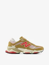 Zapatillas urbanas New Balance modelo 9060, color beige con detalles en rosa y rojo. Confeccionadas en gamuza y malla, con logo "N" característico en los laterales y entresuela con tecnología ABZORB y SBS.