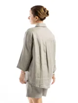 Camisa unisex de lino con mangas tres cuartos, cuello clásico, cierre frontal con botones y un bolsillo aplicado en el pecho.