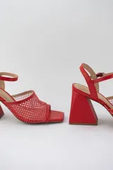 Sandalias rojas con capellada de cuero y rejilla, taco geométrico y pulsera al tobillo.