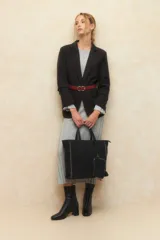 Vestido midi de punto acanalado en color gris, con mangas largas acampanadas y aberturas laterales en el ruedo. Presenta un diseño ajustado al cuerpo.