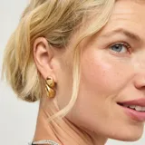 Aros colgantes de diseño orgánico y acabado brillante, con baño de oro 18k.