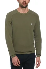 Sweater de punto con textura tipo panal en color verde oliva, de cuello redondo y manga larga. Presenta el logo de la marca bordado en el pecho.