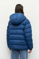 Campera puffer color ladrillo de nylon con capucha, dos bolsillos laterales con cierre y un bolsillo adicional con solapa en la manga izquierda.