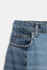 Jeans de tiro medio con diseño barrel y detalle de patchwork en denim a contraste. Cuenta con cinco bolsillos, trabillas en la cintura y cierre frontal con cremallera y botón.