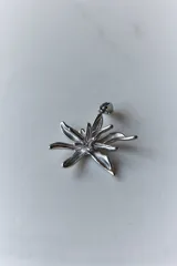 Collar con dije de acero quirúrgico en forma de flor de lirio, montado sobre un tiento de cuero encerado largo.