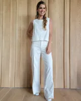 Pantalón de jean blanco de corte recto y tiro alto, con costuras verticales decorativas en el frente y ruedo desflecado.