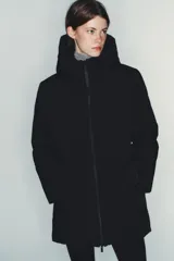 Chaqueta acolchada de color negro, resistente al agua y al viento, con aislamiento térmico. Presenta cuello subido con capucha, cierre frontal con cremallera termosellada de doble cursor, bolsillos laterales con forro polar y puños interiores elásticos.