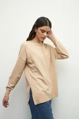 Polera negra de manga larga con puños elastizados, cuello alto y sutiles aberturas en los laterales.