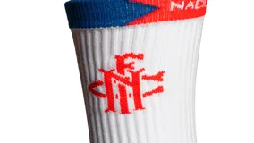 Medias deportivas blancas con detalles en azul y rojo, con logo del Club Nacional de Football y la palabra "NACIONAL" en la parte superior.