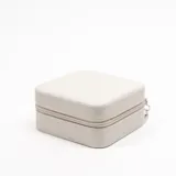 Caja cuadrada color beige con cierre de cremallera, ideal para guardar joyas y accesorios pequeños.