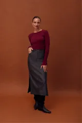 Falda larga de cuero ovino con efecto gastado, diseño tipo jeanera con bolsillos frontales y traseros, y aberturas laterales.