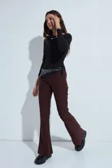 Pantalón de corte oxford, color negro, con ajuste en la cadera y pierna acampanada hacia el bajo. Presenta una silueta fluida y entallada.
