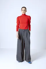 Polera de punto color rojo, con cuello alto y mangas largas con detalle de frunces en los hombros.