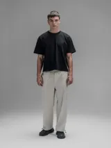 Pantalón cargo de corte oversize confeccionado en microfibra elastizada color beige. Presenta cintura elástica, bolsillos laterales y un bolsillo cargo con cierre de broche a presión. Incluye un sistema de elásticos con tancas en los tobillos para ajustar la apertura.