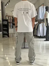 Remera oversize blanca de manga corta con estampado tipográfico y gráfico en la espalda.