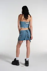 Bustier de denim celeste con cierre lateral y bolsillos decorativos frontales.