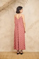 Vestido largo color rosa viejo, con breteles finos y escote en V. Presenta flecos diagonales en toda la prenda.