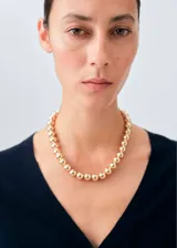 Cardigan de punto fino con cuello en pico y cierre frontal con botones. Presenta un diseño recto y mangas largas.