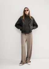 Pantalón de corte ancho, color tostado con sutiles rayas verticales en tonos marrones y oscuros, confeccionado en poliéster.