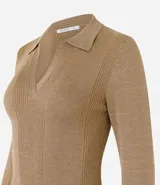 Blusa de punto ajustada color negro, con cuello polo y escote pronunciado en V. Presenta un tejido acanalado vertical en el torso y mangas largas.