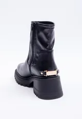 Bota corta negra de cuero sintético, con punta redondeada, plataforma de 6cm, cierre lateral y detalle metálico dorado en la parte trasera del taco.