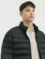 Campera capitoneada de poliéster con cierre frontal al tono y bolsillos laterales con cierre invisible.