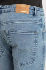 Pantalón jeans de corte slim, color azul claro con lavado light blue, confeccionado en denim premium con silueta ajustada.