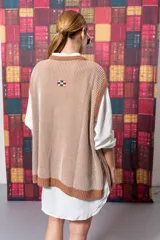 Chaleco de punto color beige con rayas verticales marrones y cuello redondo.