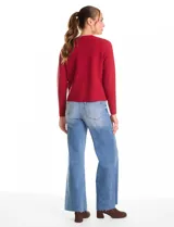 Cardigan tejido de punto color beige, con cuello a la base y cierre frontal mediante un botón metálico decorativo. Presenta mangas largas y corte recto.