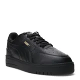 Championes urbanos Puma modelo Shuffle Downtown, de color negro con detalles en dorado. Presentan una capellada de cuero sintético con perforaciones en la puntera, cierre de cordones y suela de goma vulcanizada con tecnología SoftFoam+ para mayor amortiguación.