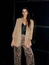 Blazer color beige de corte entallado con mangas 3/4 remangadas.