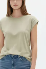 Remera de algodón color azul, de corte holgado, cuello redondo y mangas cortas con vuelta.