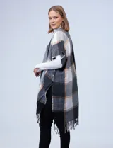 Kimono de tejido suave con diseño a cuadros en tonos blanco, negro, gris y beige. Presenta flecos en el borde inferior.