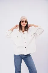 Sobrecamisa de pana color crudo, con corte oversize, bolsillos frontales con solapa y cierre de botones.