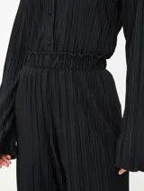 Pantalón de vestir color borgoña, de corte palazzo y tela plisada.