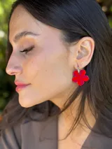 Aro colgante con gancho de acero quirúrgico y dije en forma de flor de cinco pétalos, pintado a mano en tonos rojo y fucsia.