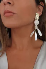 Aros colgantes con piezas geométricas doradas y detalles de nácar.