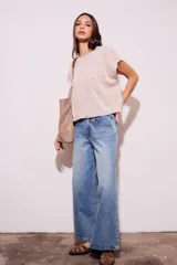 Chaleco de punto color crema con detalles en rosa y celeste, de corte holgado y mangas cortas.