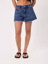 Short de denim azul de tiro medio, con corte wide leg y bordes deshilachados sin rematar.