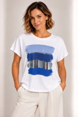 Remera blanca de manga corta y cuello redondo, con estampa frontal abstracta de pinceladas en tonos azules y plateados.