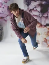 Buzo tipo hoodie con cierre frontal completo, capucha con cordones ajustables y bolsillos laterales. Confeccionado en tejido de algodón con textura jaspeada.