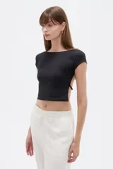Top negro de poliéster, con mangas cortas, cuello a la base y diseño ajustado al cuerpo con espalda descubierta.