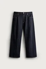 Pantalón jean azul marino oscuro de corte recto y holgado, largo cropped, tiro medio y tejido rígido de denim sin lavado. Cuenta con diseño de cinco bolsillos y costuras en tono tabaco contrastante.