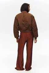 Pantalón wide leg marrón de tejido plisado con ligero brillo, cintura elástica y bolsillos laterales al bies.