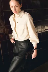 Camisa de estilo cargo color beige, confeccionada en mezcla de lino y algodón. Presenta cuello clásico, cierre frontal con botones, bolsillos superiores con solapa, charreteras en los hombros y mangas largas con puños abotonados.