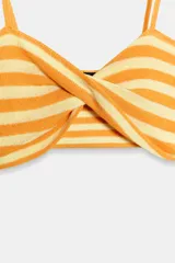 Top corto confeccionado en tejido de punto, con diseño a rayas en tonos amarillo y blanco, escote en pico con detalle de nudo y tirantes finos.